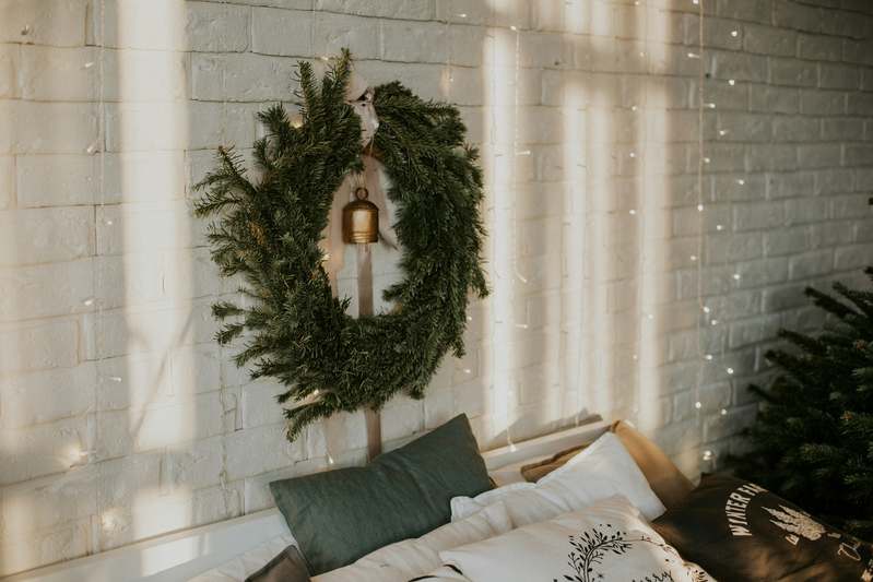 Organized craft table with wreath-making supplies: wire rings, pruners, dried florals, and linen ribbons